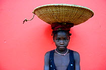 Girl carrying basket on her head, Iemberem village, Cantanhez National Park, Guinea-Bissau, December 2013.