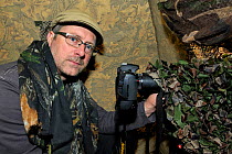 Photographer, Michel Poinsignon, in a hide. November 2011.