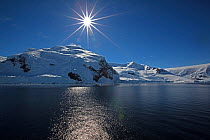 Sun shining over coastal landscape, Antarctica, November 2012.