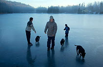 Family with dogs on newly frozen ice, Akershus, Norway, December 2012.
