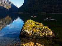 Kayakers in Naeroyfjorden World heritage site, Sogn and Fjordane, Norway, October 2009.