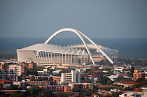 Moses Mabhida stadium towering over houses and blocks of flats, KwaZulu-Natal, Durban, South Africa, August 2009.