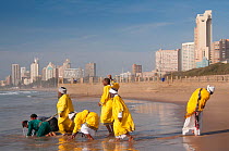 Traditional healers performing a baptism on Durban beach, KwaZulu-Natal, South Africa, August 2009.