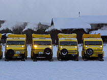 Bombardier snow coaches lined up outside winter lodge, Yellowstone National Park, Wyoming, USA, February 2014.