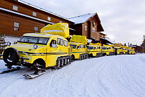 Bombardier snow coaches lined up in front of Old Faithful Snow Lodge, Yellowstone National Park, Wyoming, USA, February 2014.