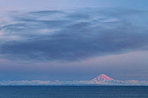 Mount Redoubt Volcano at sunrise in winter, Lake Clark National Park Coast, seen from Homer, Cook Inlet, Alaska, USA, March 2013.