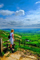 Female walker looking from Mam Tor to the Hope Valley Nr Castleton, Peak District National Park, Derbyshire, England, May 2014