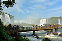 Tourists on bridge observing Iguasu Falls, Iguasu National Park, Brazil, April 2013.