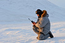Man looking at phone with antennae Wrangel Island, Far Eastern Russia, March 2011.