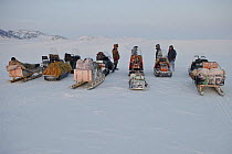 Men on snowmobiles removing items from bringing items to photographers camp, Wrangel Island, Far Eastern Russia, March 2011.