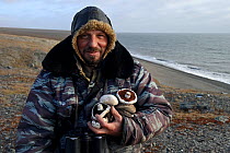Man holding mushrooms on coast of Wrangel Island, Far Eastern Russia. September 2010.