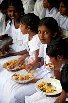 School children having lunch in village school, Sri Lanka, March 2005.