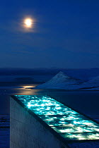 Moon and glittering facade designed by artist Dyveke Sanne, on the roof of the Svalbard Global Seed Vault. Light reflected in steel, mirrors, and prisms in landscape, Svalbard, Norway, October 2012