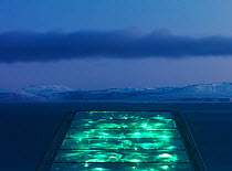 Svalbard Global Seed Vault, with glittering facade designed by artist Dyveke Sanne., on the roof of the Svalbard Global Seed Vault. Light reflected in steel, mirrors, and prisms in landscape, Svalbard...