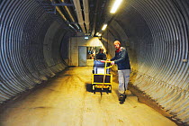 Man transporting newly arrived seeds to the inner part of the vault, Svalbard Global Seed Vault, Svalbard, Norway, October 2012.