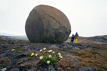 People looking at spherical stones, Champs Island, Franz Josef Land, Russian Arctic, July 2004.