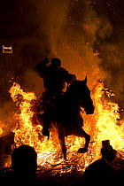 Man jumping through fire to purify his horse, during the Luminarias festival, held every January in San Bartolome de Pinares, Avila Province, Castile and Leon, Spain, January 2014.