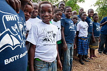 Local school children proudly wearing Kasanka Trust t-shirts on a visit to the National Park to see the mass aggregations of straw-coloured fruit bats (Eidolon helvum). Kasanka National Park, Zambia. November 2013.