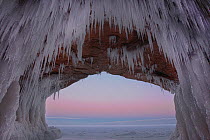 Icicles hanging from sandstone archway in sea cave at dawn. Apostle Islands National Lakeshore, Lake Superior, Squaw Bay, Wisconsin, February 2014. Exposure composite of 3 images.