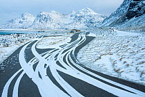 Car tracks in snow, at parking area, Skagsanden beach, Flakstad municipality, Lofoten, Nordland, Norway. January 2010