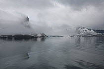 Horn shaped peak of Bautaen, surrounded in soft cloud. Hornsundfjord, Spitsbergen, Svalbard, Norway.