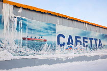 A large poster, partly covered by snow and ice, of a ship transporting Liquid Natural Gas at Sabetta, South Tambey Gas field, Yamal, Siberia, Russia. February 2014.