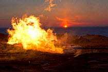 The winter sun setting behind a gas flare at a drilling site in the South Tambey Gas Field, Yamal Peninsula, Siberia, Russia. February 2014.