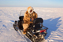 Jakov Vanuito, a Nenets reindeer herder, checks his GPS during a  snowmobile journey across the tundra in the South Tambey Gas Field, Yamal Peninsula, Siberia, Russia. February 2014.