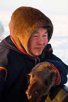 Nenets reindeer herder at winter camp on the tundra in the South Tambey Gas Field, Yamal Peninsula, Siberia, Russia. February 2014.