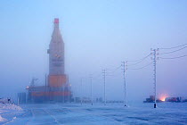 Fog surrounding a gas drilling derrick at dusk, near the South Tambey Gas Field, Yamal Peninsula, Siberia, Russia. February 2014.
