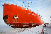 A Russian ice strengthened ship, Yuri Arshevsky, delivers her cargo to Sabetta during the winter. Yamal Peninsula, Siberia, Russia. February 2014.