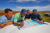 Food and Agriculture Organization (FAO) experts - Hasina Rakotovao (with green shirt, locust scout) with his crew for locust ground control operations, discussing situation in operation area. Tsiroanomandidy, Madagascar December 2013.