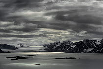 Landscape on overcast day at Kongsfjorden, with mountains in the background, Svalbard, Norway. July 2011.
