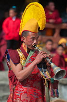 Buddhist monk playing trumpet during Torgya festival. Galdan Namge Lhatse Monastery, Tawang, Arunachal Pradesh, India. January 2014.