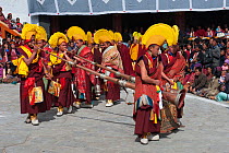 Buddhist monks playing long trumpets (Lawa) during Torgya festival. Galdan Namge Lhatse Monastery, Tawang, Arunachal Pradesh, India. January 2014.