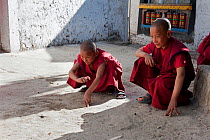 Young monks playing marbles during a break at the Torgya festival. Galdan Namge Lhatse Monastery, Tawang, Arunachal Pradesh, India. January 2014.