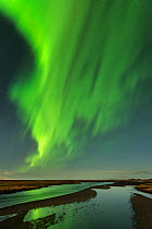 The Northern Lights / Aurora Borealis over a river, Vik, Iceland. February 2014.