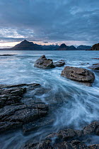 Waves washing up Elgol beach in the evening light with a view of the Cuillins, Strathaird peninsula, Isle of Skye, Scotland, UK. December 2013.