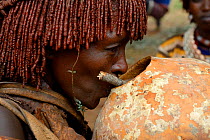 Hamer woman drinking sorgho beer during the Ukuli ceremony. Hamer tribe, Omo river Valley, Ethiopia, September 2014.
