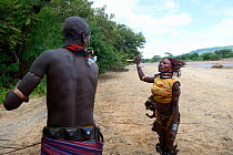 During the Ukuli ceremony and before the bull jumping, the Maza (young initiated men) whip the Hamer women who will defy them, showing no fear or signs of pain. Hamer tribe, Omo river Valley, Ethiopia...