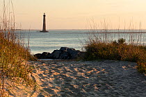 Morris Island Lighthouse viewed from the north end of Folly Island, South Carolina, USA.