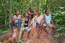 Group of Mbuti Pygmies looking about with bows before Mota hunting. This is a group bow and arrow hunting using beat method hunting. The dogs have wooden bells attached to its neck and are used to dri...
