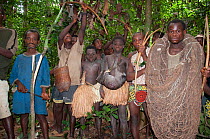 Mbuti pygmy initiation hunt, with two boys in traditional blue body paint and straw skirt. One boy is holding catch of Blue Duiker (Philantomba monticola). As well as using bows and arrows in this hun...