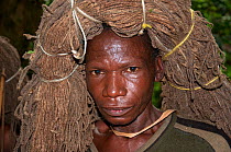 Mbuti Pygmy man carrying throwing net on head for initiation hunt, Ituri Rainforest, Democratic Republic of the Congo, Africa, November 2011.