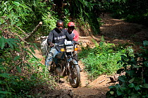 Ituri Forest Pygmy guides on motor bike, Democratic Republic of the Congo, Africa, December 2011.