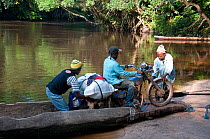 Mongo porters moving bicycles loaded with goods off canoe, Democratic Republic of the Congo, Africa, November 2011.