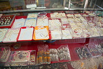 Fake ivory necklaces made from plastic for sale in shop, Nakhon Sawan, Thailand, December 2012