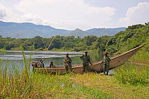 Park rangers with wooden motor boat, Ishango, Virunga National Park, UNESCO World Heritage Park, Democratic Republic of the Congo, January 2012.