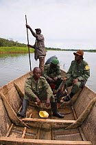 Park rangers in wooden motor boat, Ishango, Virunga National Park, UNESCO World Heritage Park, Democratic Republic of the Congo, January 2012.