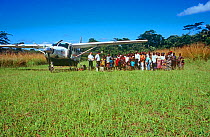 Batwa Pygmy villagers on Monkoto airstrip with 'Aviation Sans Frontier' pilots and plane. Democratic Republic of the Congo, 2008-2009.